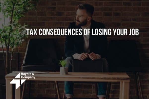 Man sitting on a couch considering tax consequences of losing a job, logo of Haynie.
