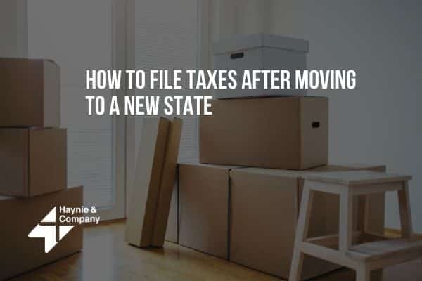 Moving boxes in a room with text: How to file taxes after moving to a new state by Haynie.