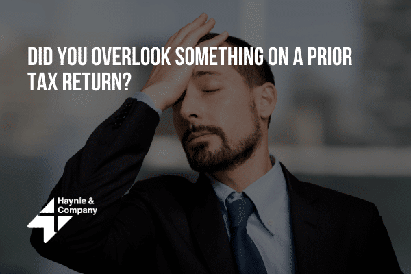 Frustrated man in suit with hand on forehead under Did you overlook something on a prior tax return? text.