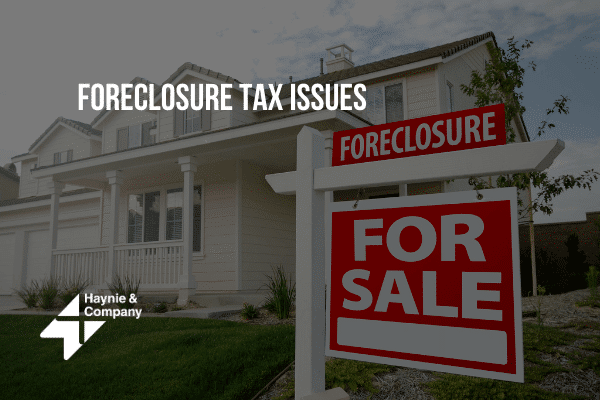 For sale sign by foreclosed house, addressing foreclosure tax issues.