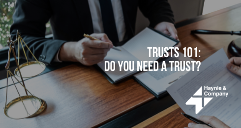 Trusts 101: Do You Need a Trust? text next to a person writing in a notebook.