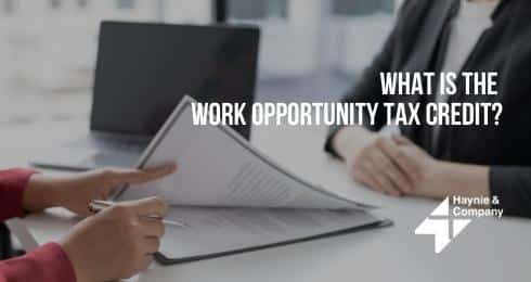 Two people discussing documents on Work Opportunity Tax Credit at a desk.