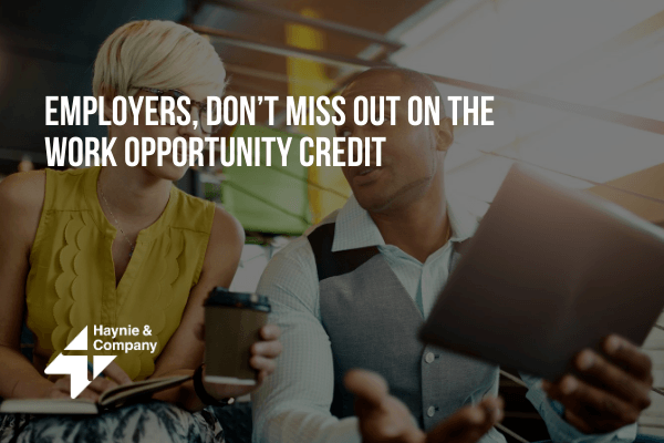 Two people discussing work opportunity credit, one holding a coffee cup, the other a tablet.