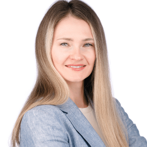 A woman in a blue blazer smiling confidently at the camera, on a white background.